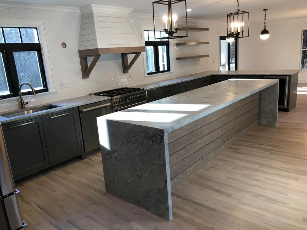 Kitchen with a gray stone waterfall island