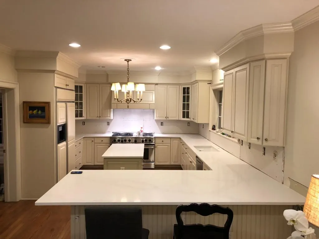 Large U-shaped kitchen with white stone countertops