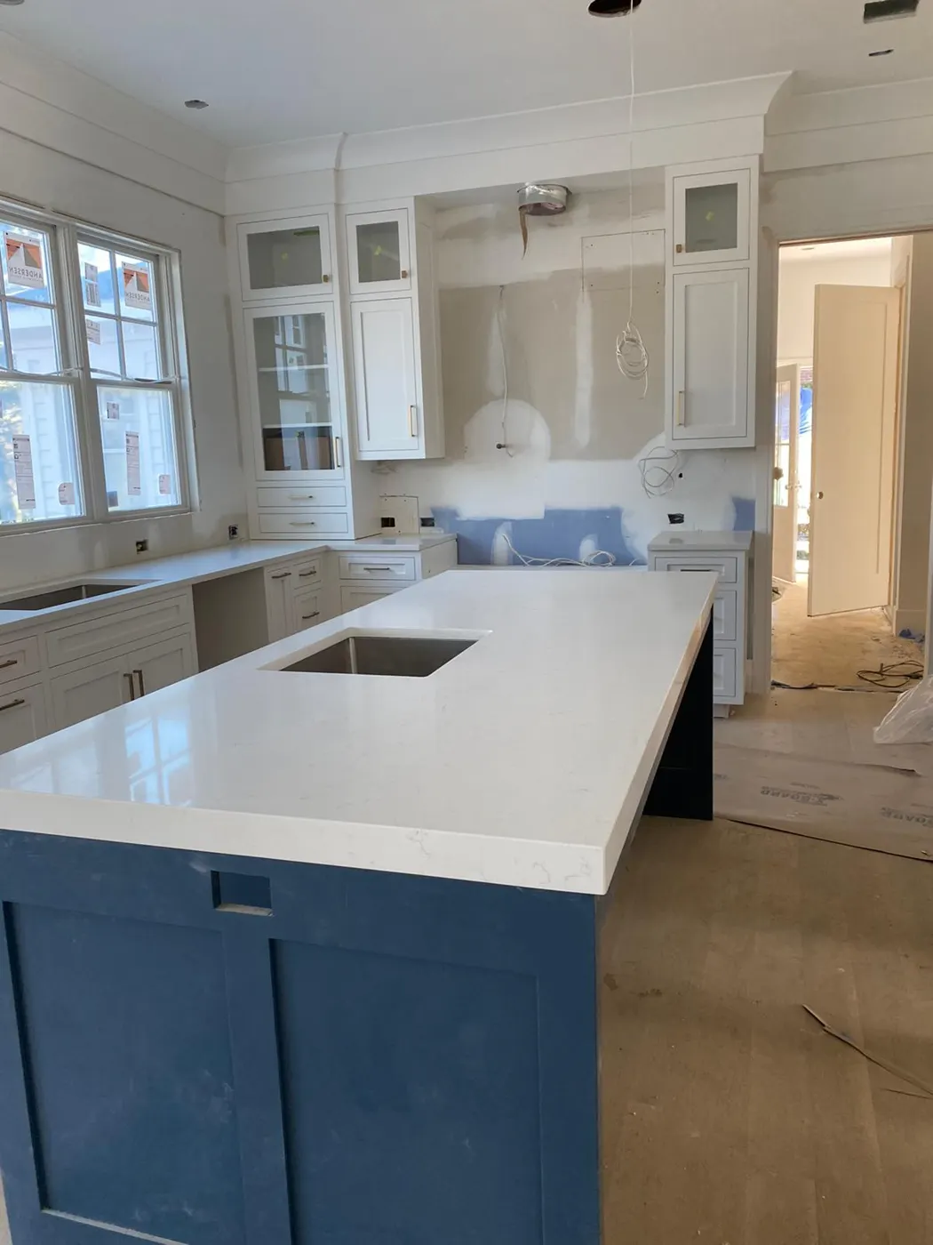 Kitchen island with a white countertop and blue cabinets